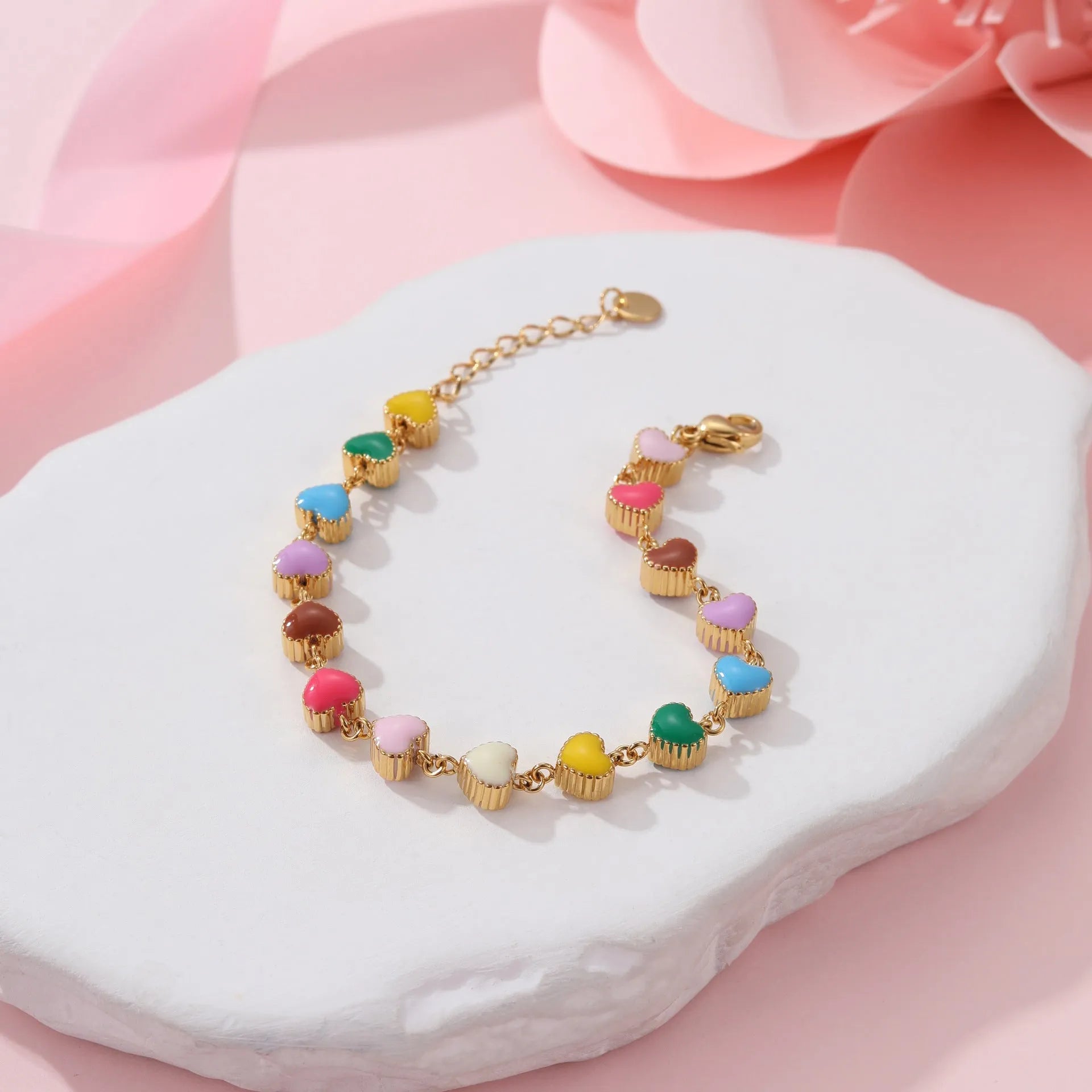 Close-up of a women's love heart-shaped bracelet in stainless steel with 18K gold plating.