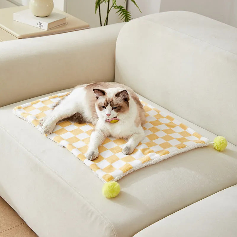 Plush pet blanket with plaid pattern and decorative fur ball in green colour