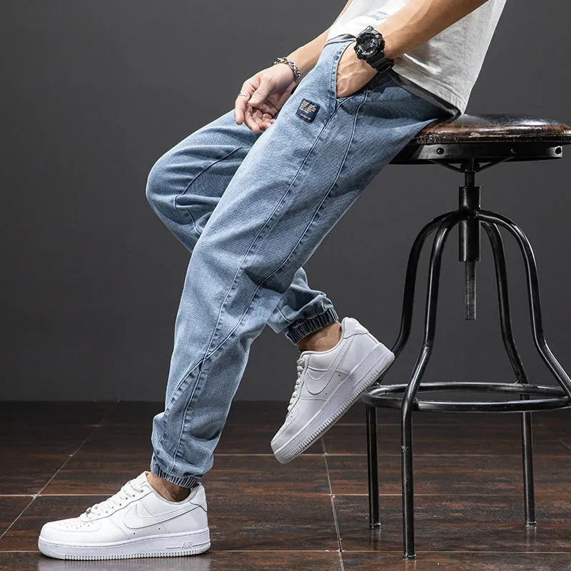 Man wearing loose fit blue cargo jeans with a straight leg and skinny ankle opening.