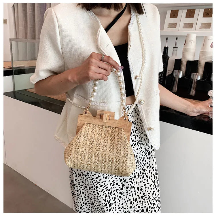 Women's straw woven shoulder bag with pearl chain strap in horizontal square shape showing internal organisers