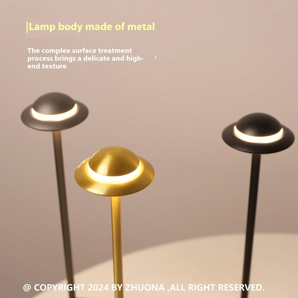 Gold UFO-shaped rechargeable table lamp with touch dimming controls on metallic surface