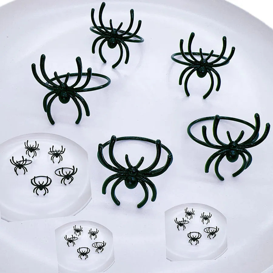 Set of six black alloy spider-shaped napkin rings for Halloween table decoration