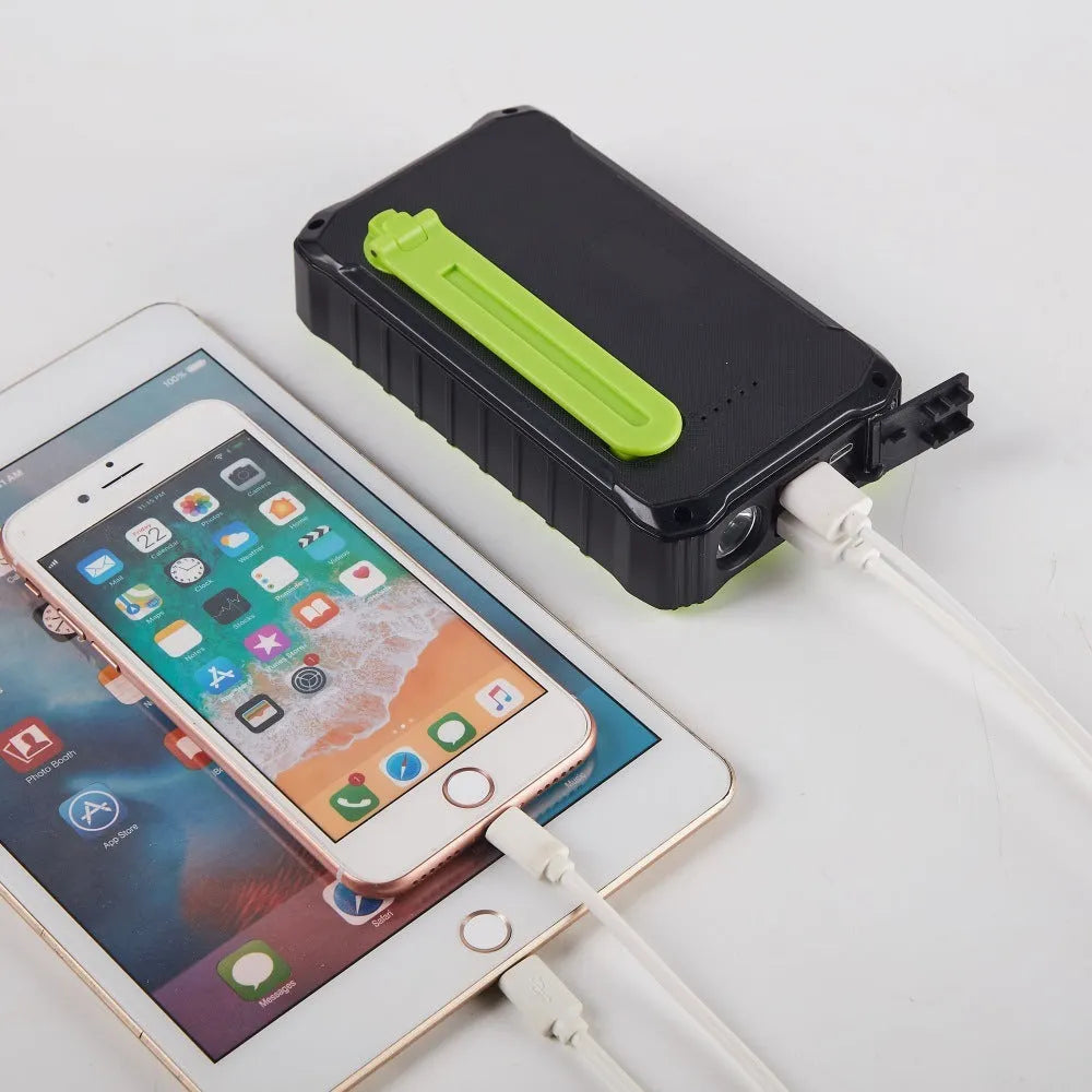 Orange and green portable solar hand crank power bank with USB ports and LED light