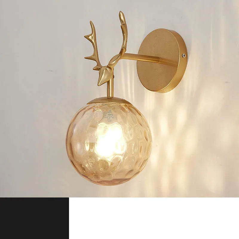 Nordic minimalist round glass wall lamp in golden finish mounted on a wall.