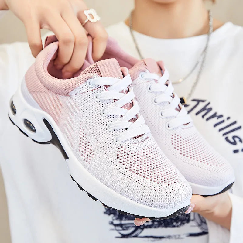 Women's Flyknit casual running shoes in striped pattern with lace-up front, shown in pink colour.
