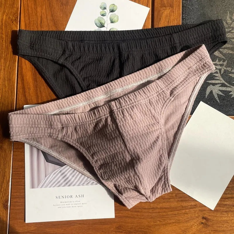 Men's pure cotton triangle underwear briefs in solid colours like black, white, and apricot on a mid-waist fit model.