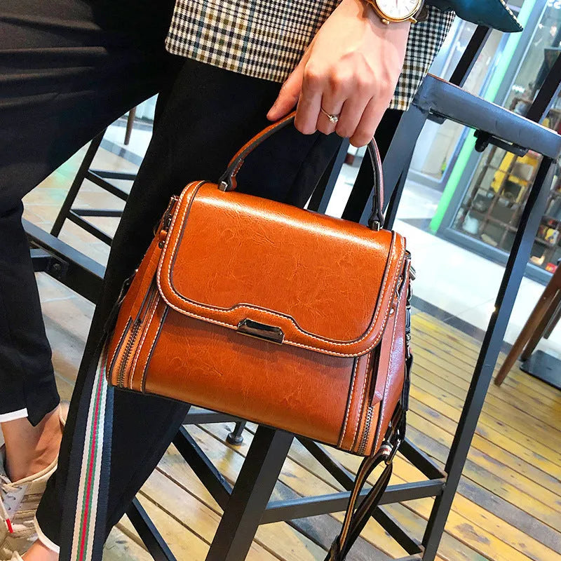 Women's brown genuine leather messenger bag with retro styling and multiple internal pockets