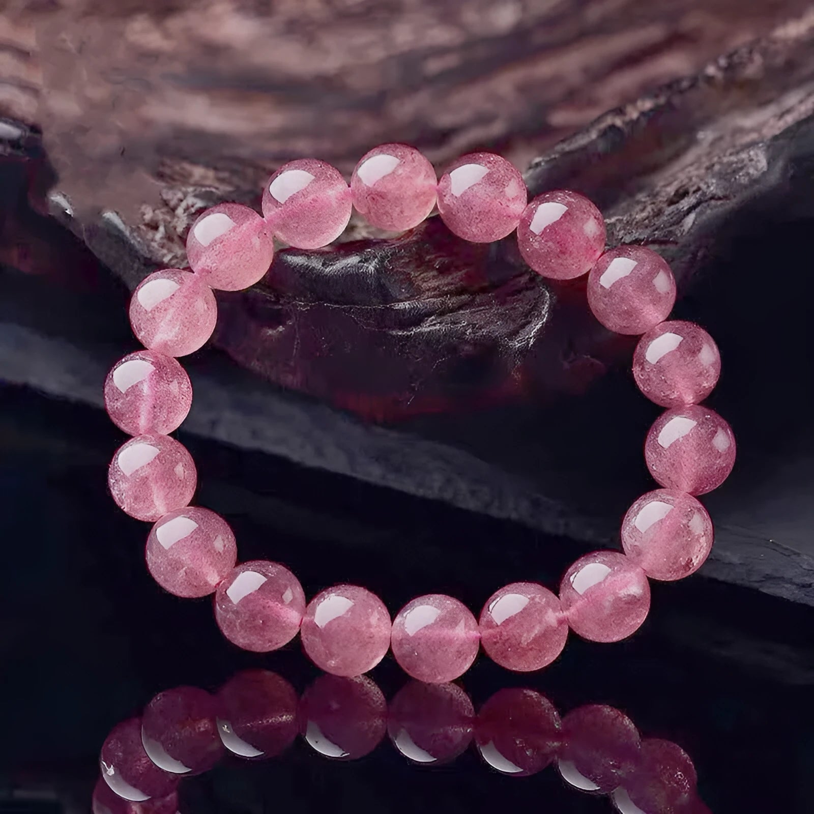 Women's strawberry quartz crystal bracelet showing polished beads in 6mm, 8mm, and 10mm size options