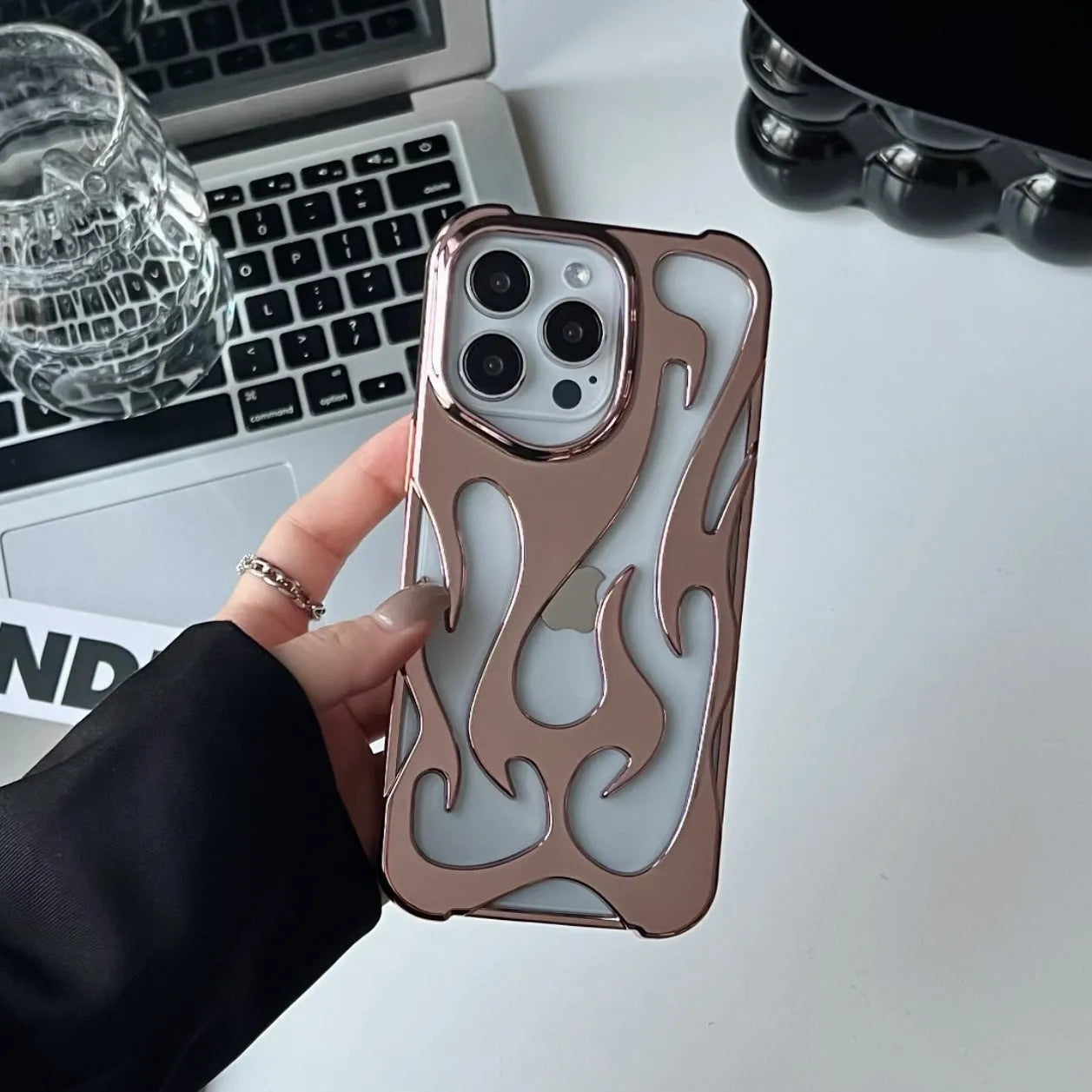 Electroplated hollow flame pattern TPU iPhone case in silver plating shown on a phone.