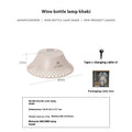 Beige wine bottle shaped rechargeable camping lantern with LED light on a wooden surface.