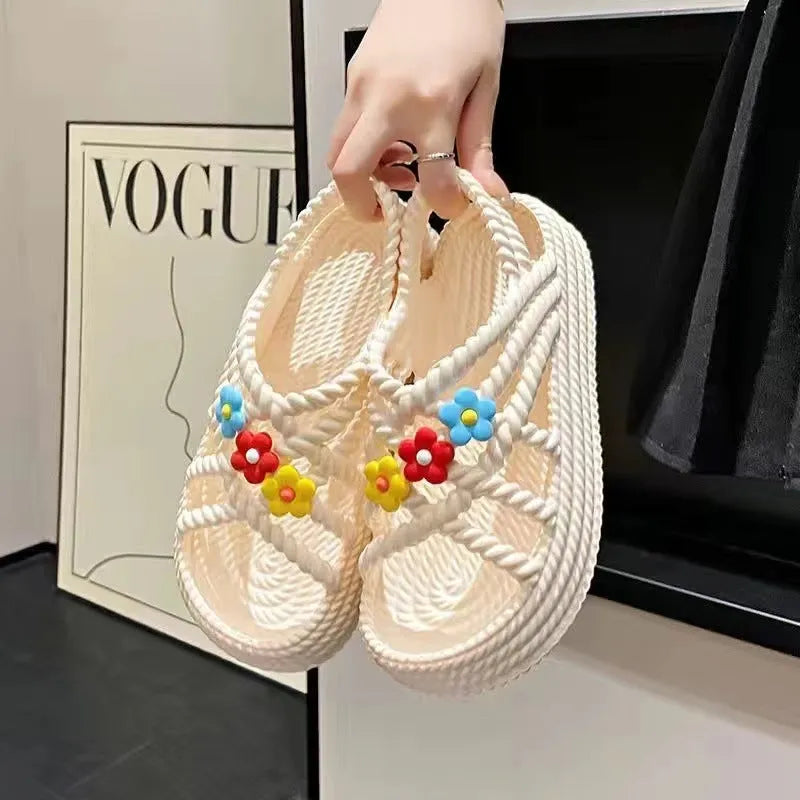Beige women's flat sandals with a three-flower decoration and a non-slip PVC sole.