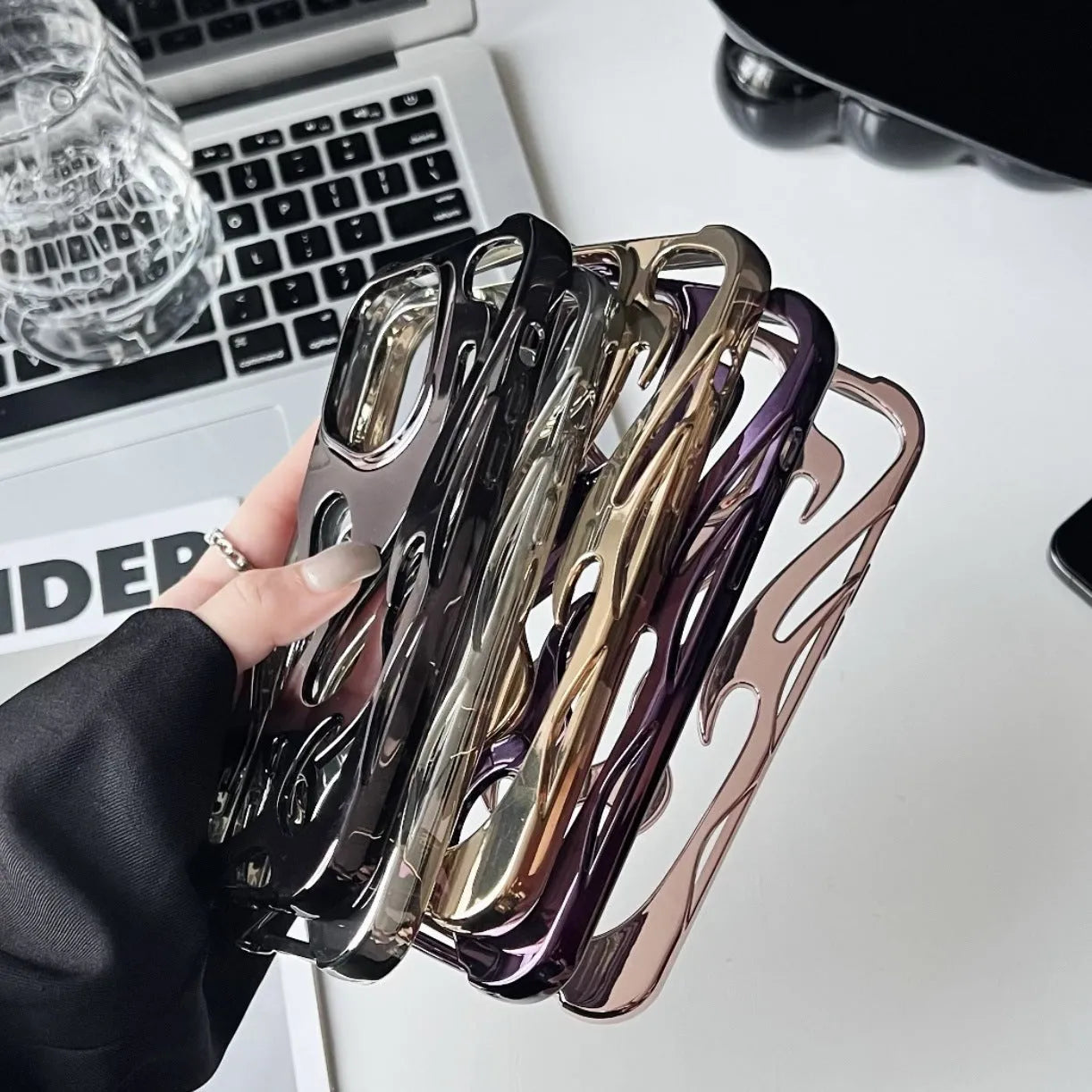 Electroplated hollow flame pattern TPU iPhone case in silver plating shown on a phone.