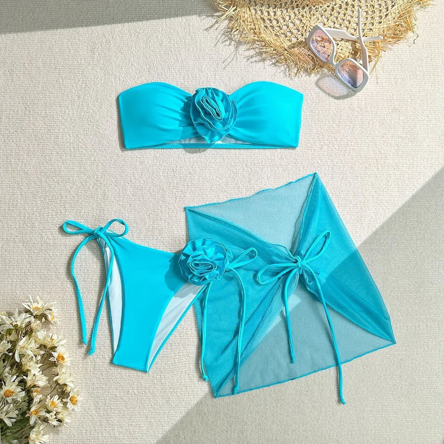 Women's pink tube top bikini with large 3D flower, matching bottoms, and skirt laid flat.