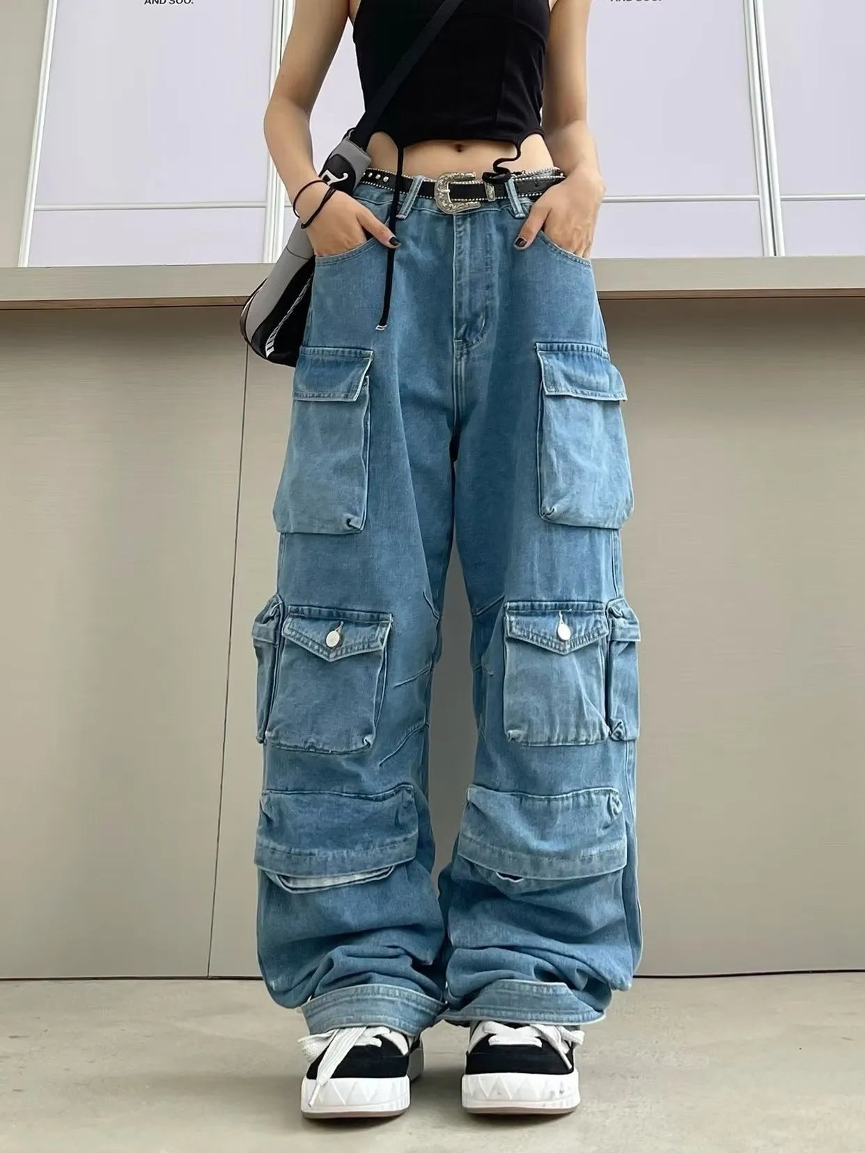 Woman wearing blue tie-dyed high waist wide leg denim trousers with multiple pockets