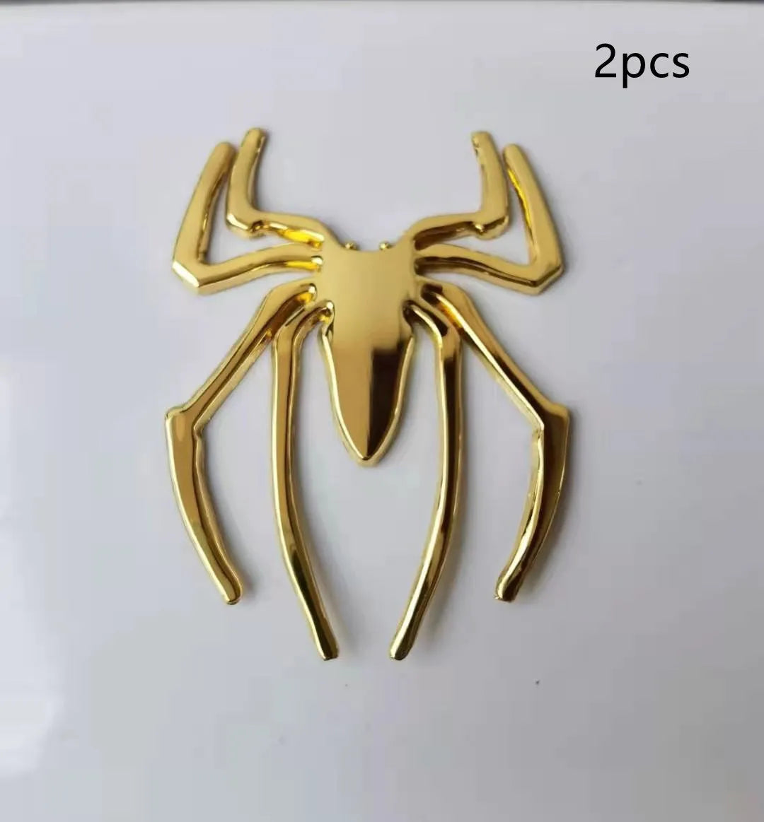 Three-dimensional metal spider bumper sticker in zinc alloy, shown in gold colour.