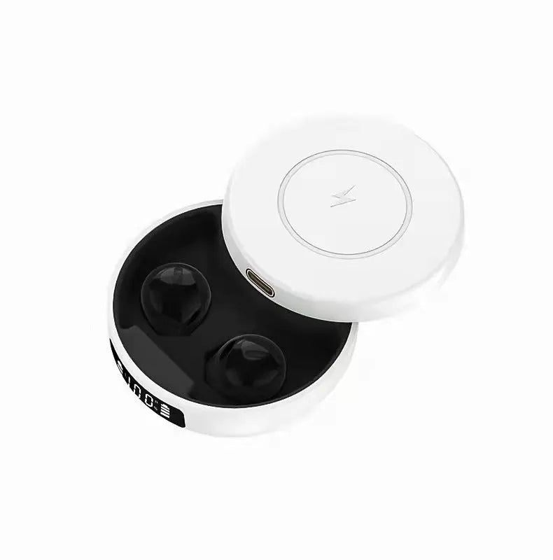 Mini black and white semi-in-ear wireless headphones with their charging case on a table.