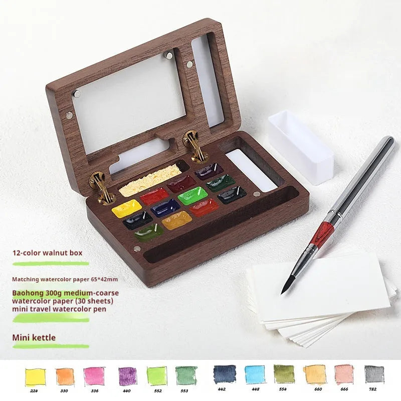Mini walnut wooden watercolour paint box set with leather carry case, open to show professional artist pigments.