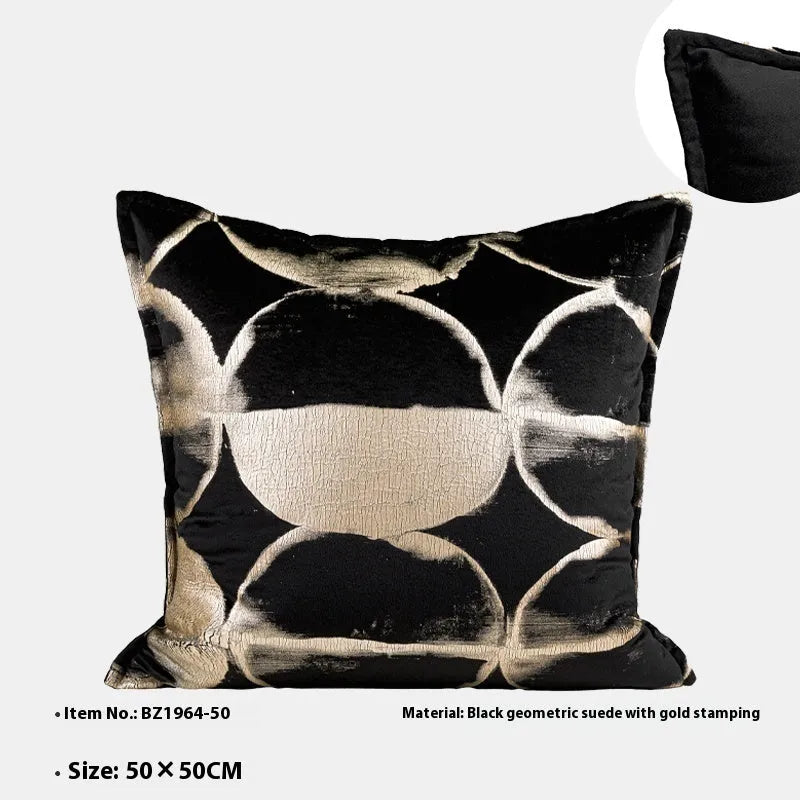 Black and gold abstract patterned flannel cushion on a sofa, showing removable cover.