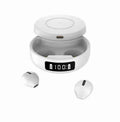 Mini black and white semi-in-ear wireless headphones with their charging case on a table.