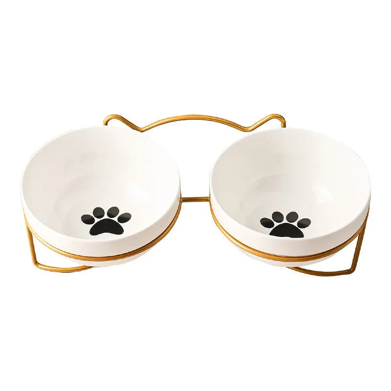 White ceramic cat bowl with decorative pattern sitting in a black iron frame stand.