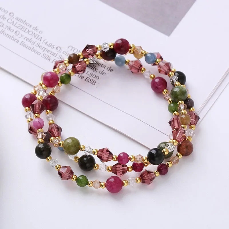 Women's handcrafted three-ring crystal bracelet with tourmaline, strawberry quartz, and amethyst beads on adjustable cord