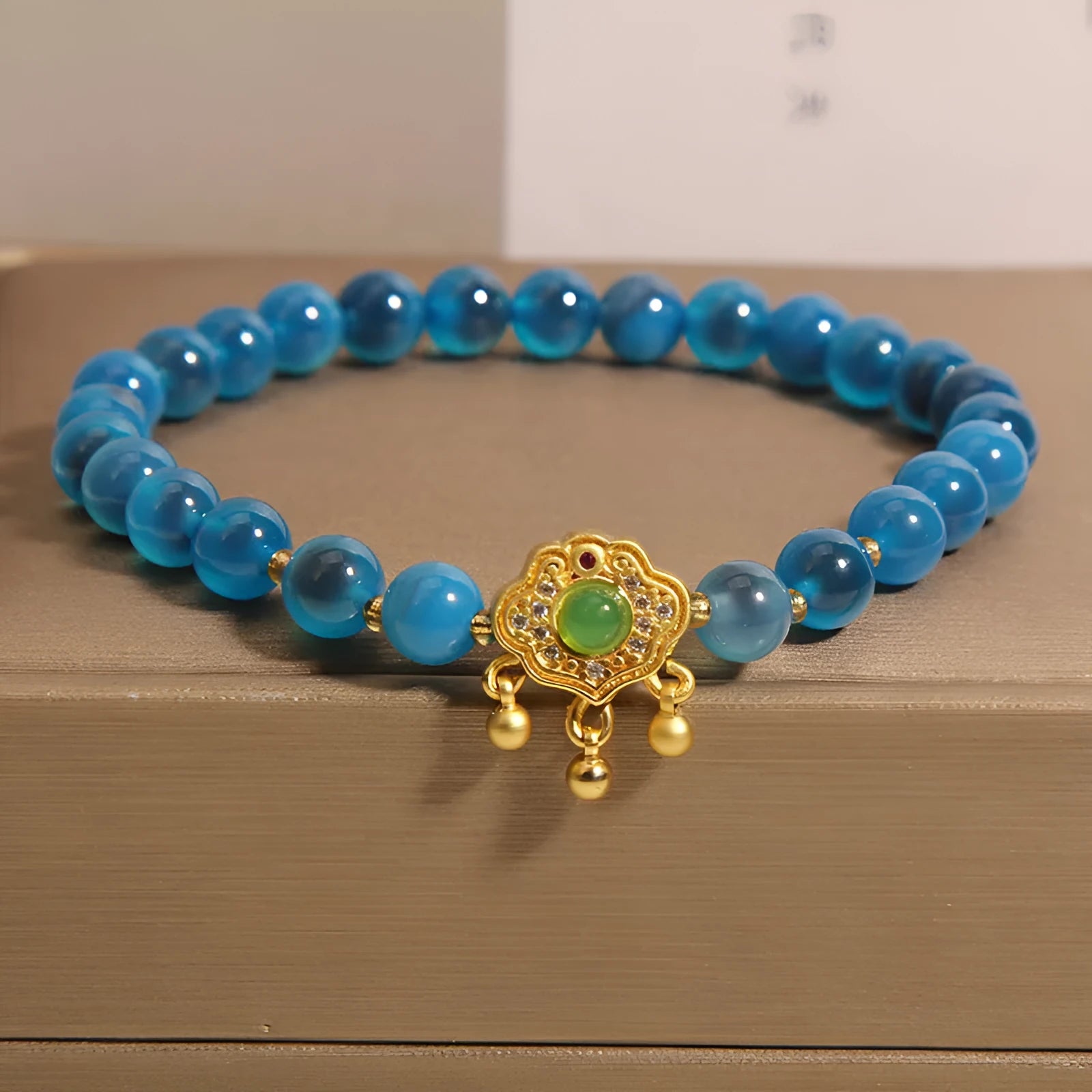 Blue sugar heart agate safety lock pendant on a crystal women's bracelet with rhinestone details.