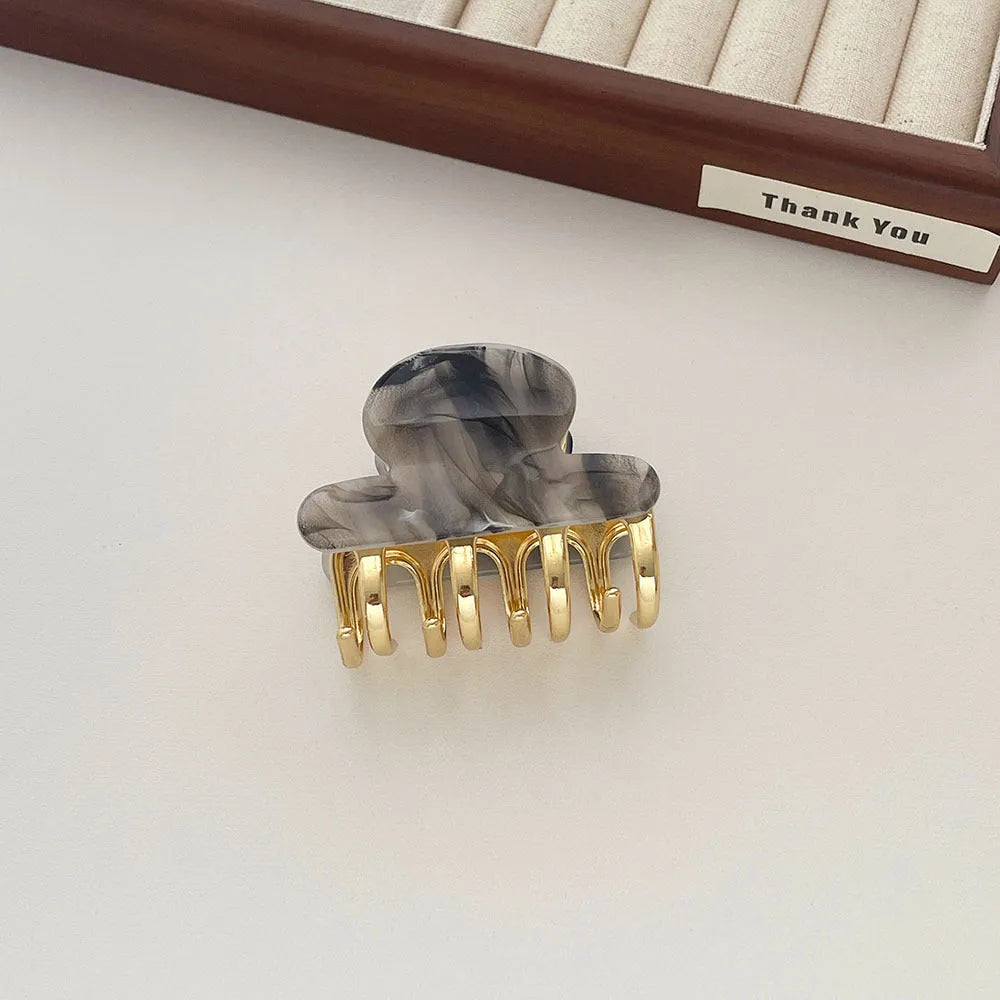 A medium-size retro-style hair barrette with a metal grip, in an alloy acrylic construction.