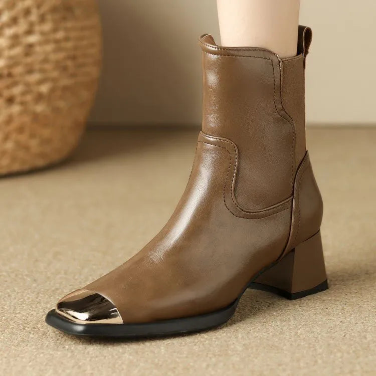 Brown cowhide leather Martin boots with side zip and high heel on wooden floor