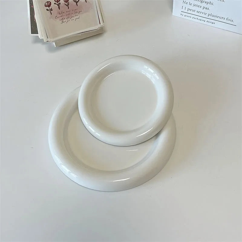 White round ceramic plate with bear doodle design, used as a saucer for a small succulent plant pot.