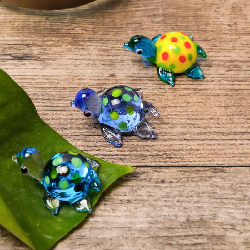 Geometric glass turtle ornament in a modern style with a coloured shell, displayed on a desktop.