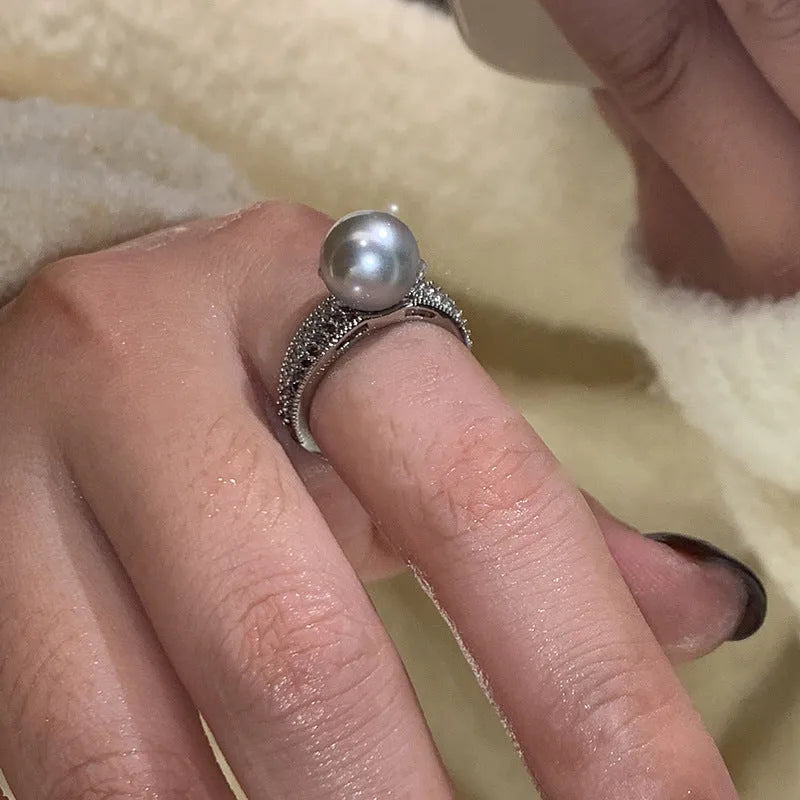 Geometric open copper ring with black pearl finish on a model's finger, showing adjustable design.