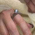 Geometric open copper ring with black pearl finish on a model's finger, showing adjustable design.