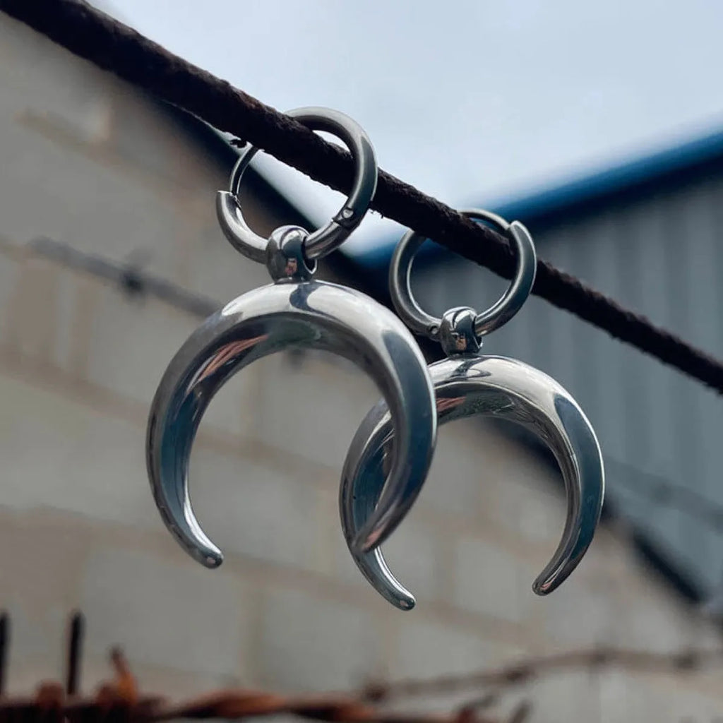 Silver-colour large hoop earrings with moon detailing and geometric shape on ear clip fastening