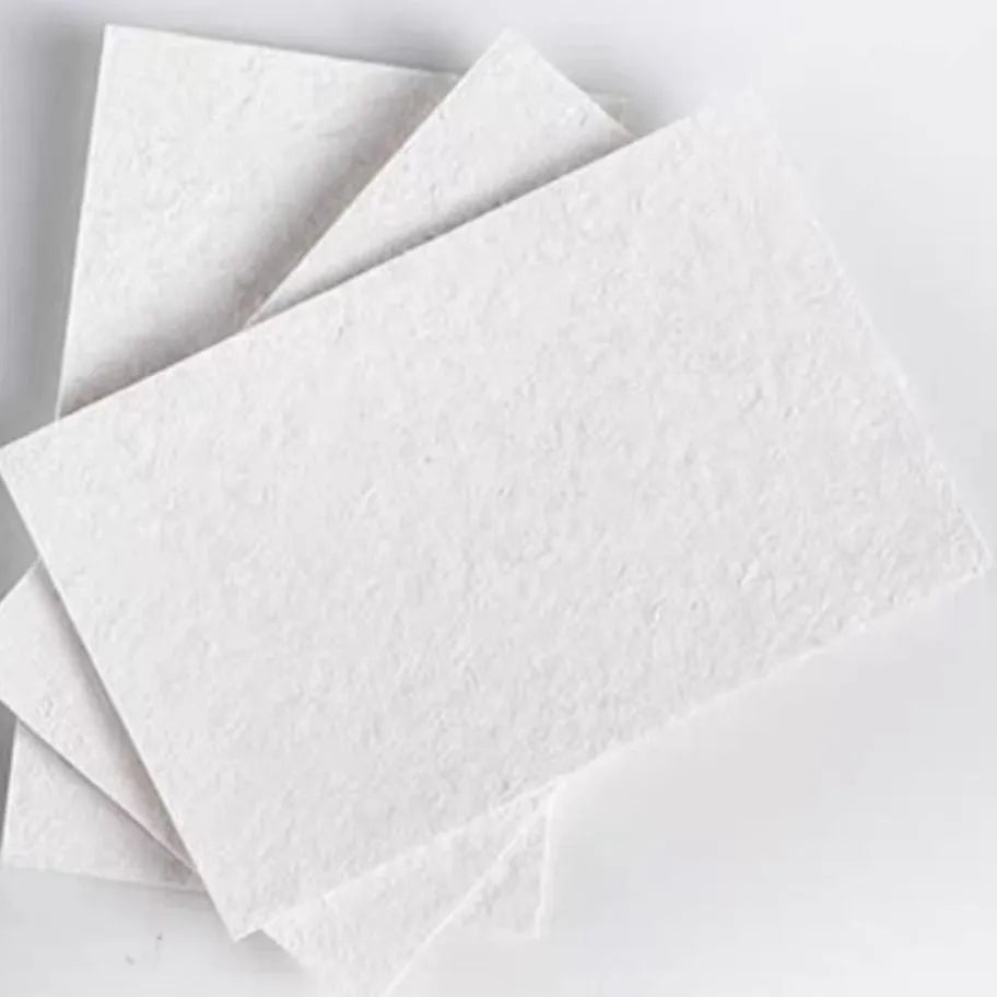 Painting sponge set showing heart, round, and square cellulose sponges with a stack of wood pulp paper for watercolour art.