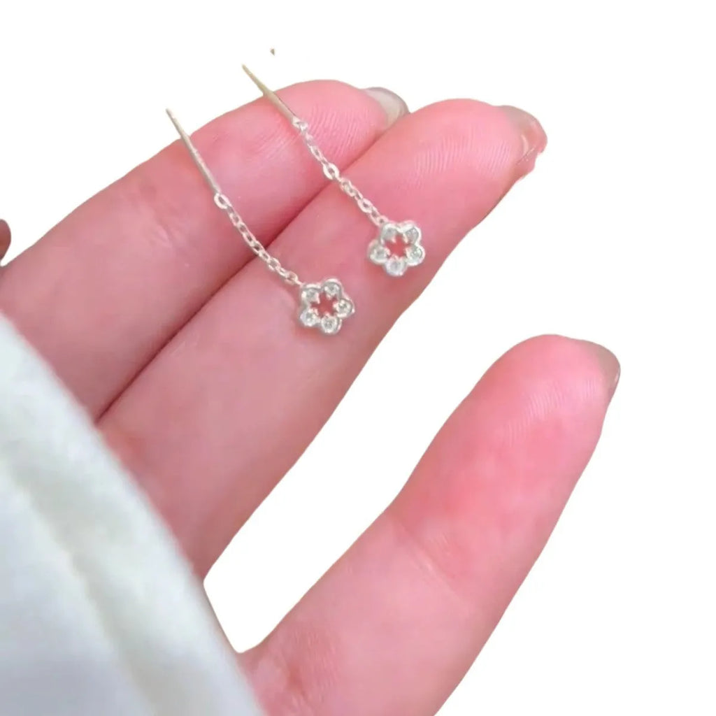 Pair of silver colour hollow flower stud earrings with detailed petal elements and needle posts