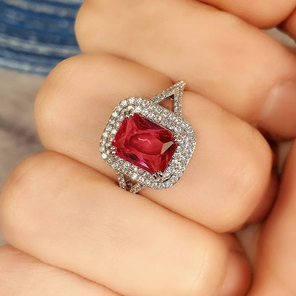Women's square ring with copper band and red rhinestones on a geometric face.