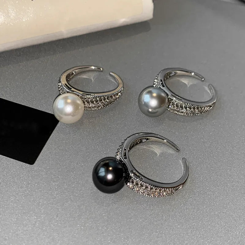 Geometric open copper ring with black pearl finish on a model's finger, showing adjustable design.