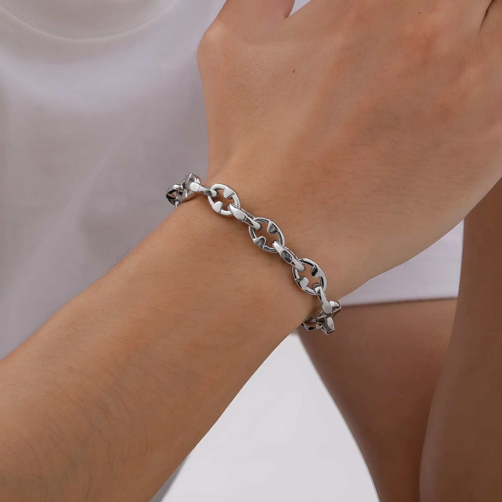 Stainless steel thick geometric chain bracelet on a wrist, showing handmade links and steel colour finish.