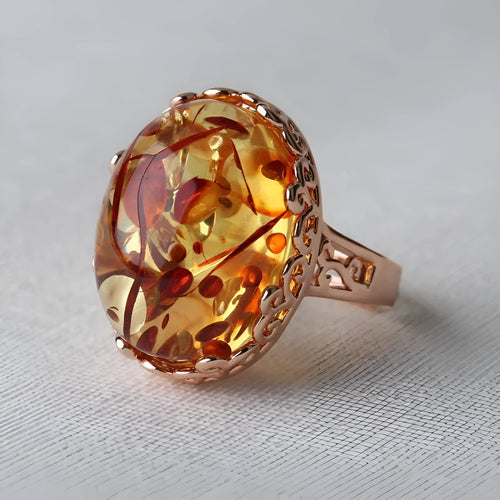 Close-up of a genuine beeswax amber ring in New Amber Type A colour on an alloy band.