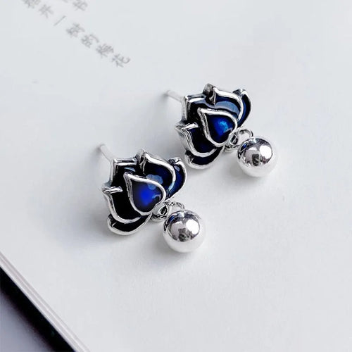 Blue lotus flower ear studs with seedpod tassel detail on an alloy backing.