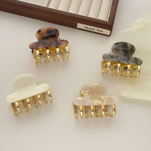 A medium-size retro-style hair barrette with a metal grip, in an alloy acrylic construction.