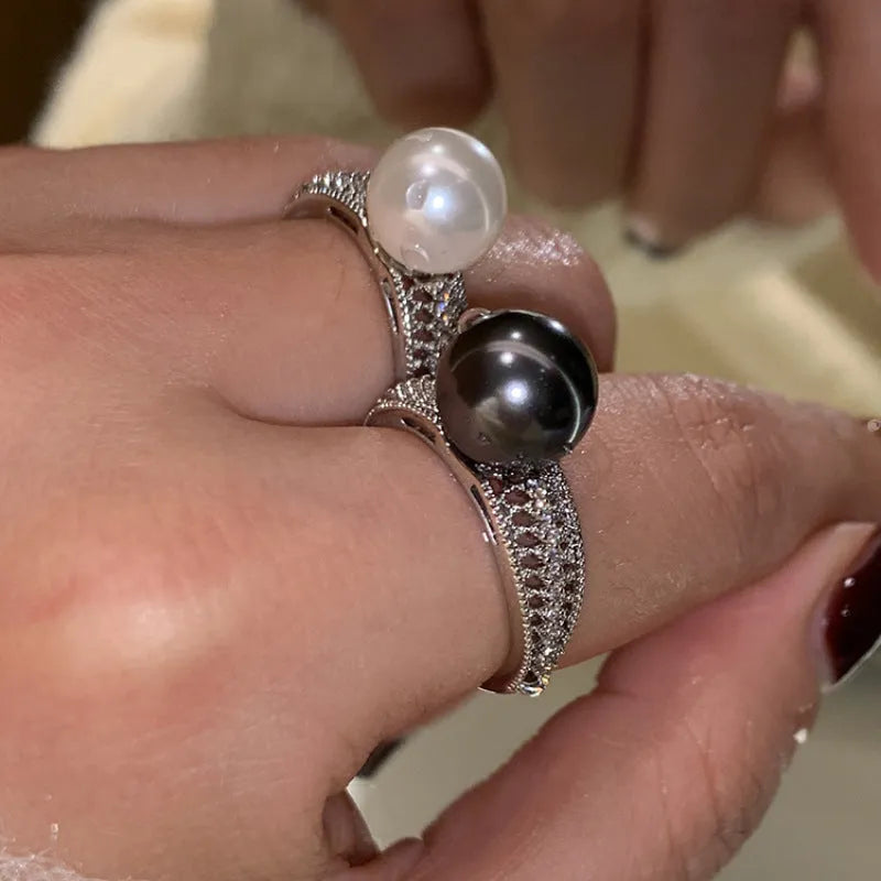 Geometric open copper ring with black pearl finish on a model's finger, showing adjustable design.