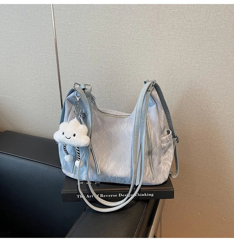 Soft black women's fashion backpack made from wear-resistant PU material, shown with a matching pendant.