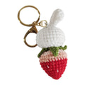 Hand-woven white wire rabbit strawberry pendant on a key.