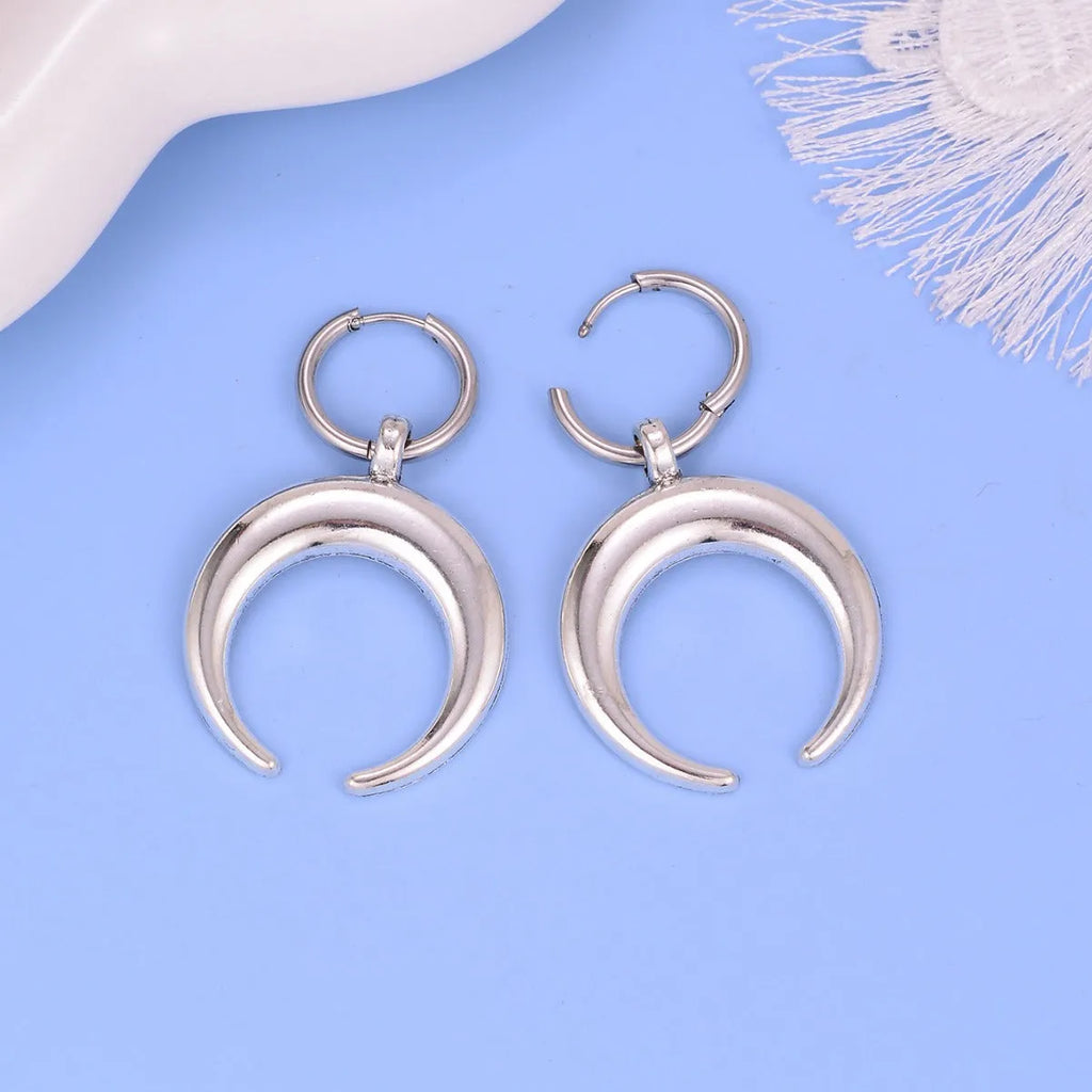 Silver-colour large hoop earrings with moon detailing and geometric shape on ear clip fastening
