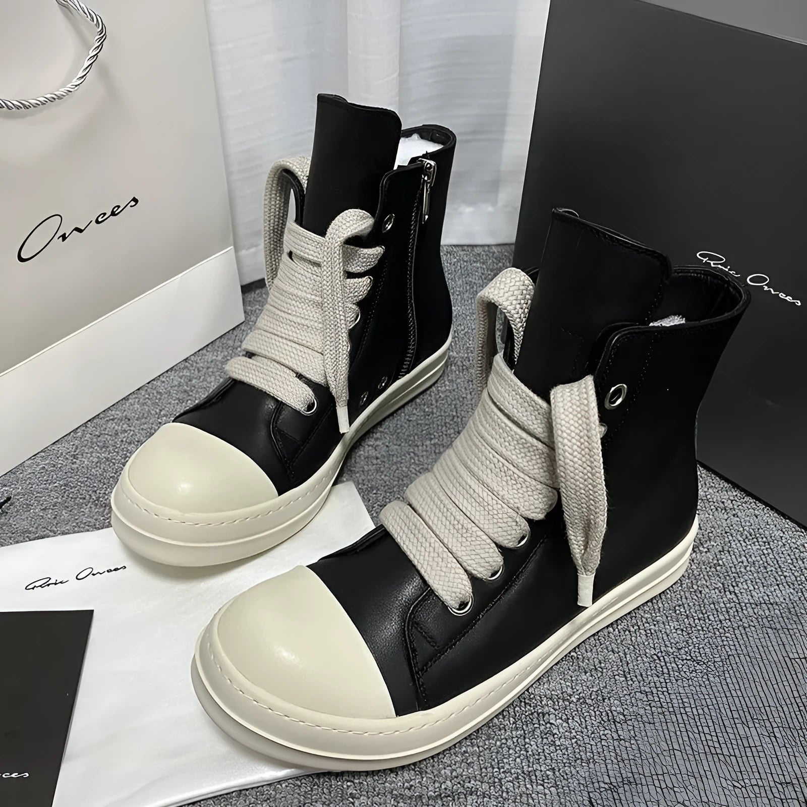 Men's black high-top leather sneakers with a side zip on a white background