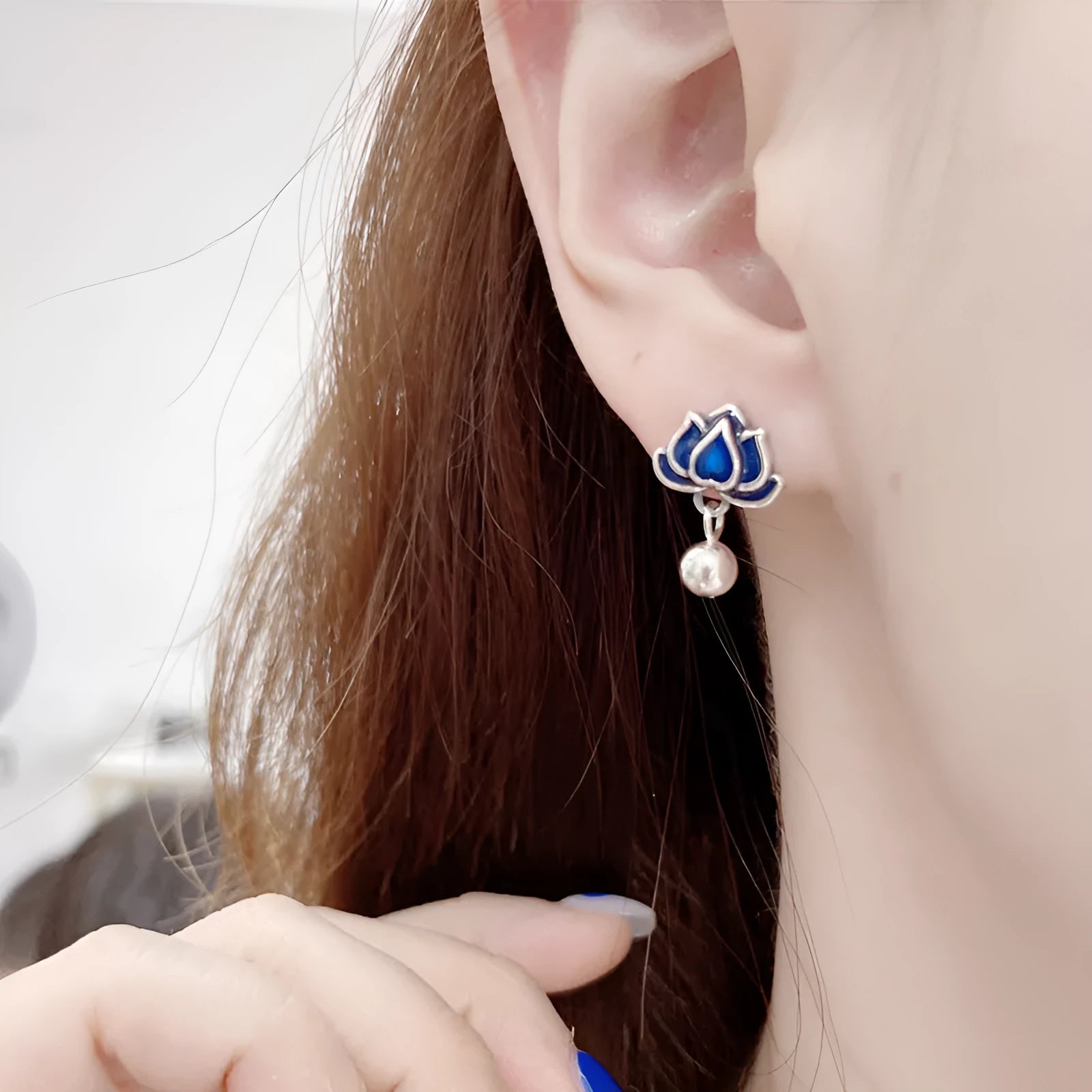 Blue lotus flower ear studs with seedpod tassel detail on an alloy backing.
