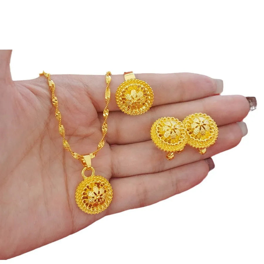 Gold-plated three-piece jewellery set with necklace, earrings, and ring in a floral design.