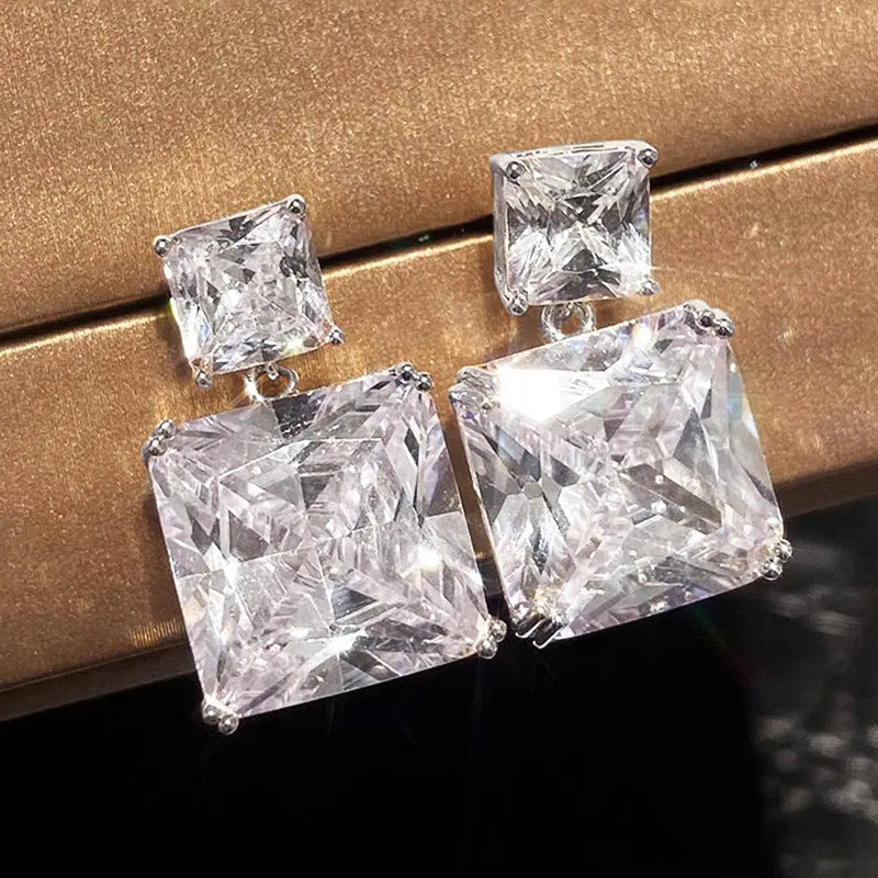 A pair of geometric square copper earrings with a quadrilateral design, shown in white gold and gold colour options.