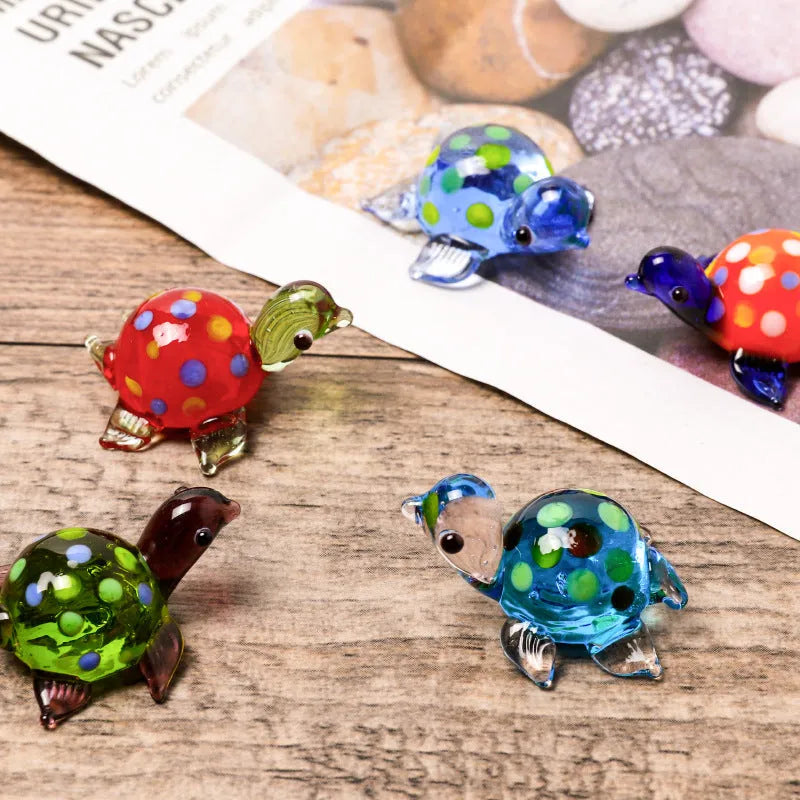 Geometric glass turtle ornament in a modern style with a coloured shell, displayed on a desktop.